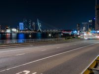 an empty freeway with the city skyline in the distance at night time in this image