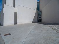 the gray concrete walls of a building have a line of steps on the left side