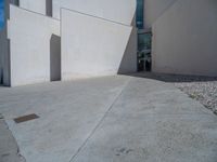 the gray concrete walls of a building have a line of steps on the left side