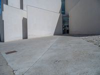 the gray concrete walls of a building have a line of steps on the left side