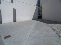 the gray concrete walls of a building have a line of steps on the left side