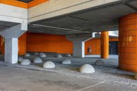 a large parking garage with orange walls and columns for seating area in front of the garage