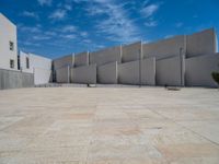 the gray concrete walls of a building have a line of steps on the left side