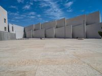 the gray concrete walls of a building have a line of steps on the left side