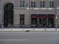 the front of the hotel has two parking meters with red awnings on it