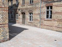 a person riding a skateboard on a brick road next to a building with windows