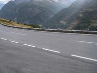 a highway with mountains on both sides, and one car driving down the road on it