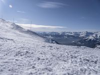 man standing in the snow with skis looking over mountain ranges from top of mountain