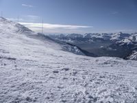 man standing in the snow with skis looking over mountain ranges from top of mountain