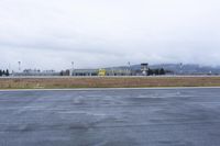 a large airport with runway, grass and field and large building behind it that reads king county international