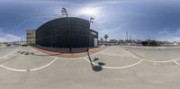 a large building is seen through the 360 - degree lens of this image of an empty parking lot