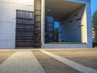 a parking lot surrounded by concrete walls and large windows with vertical lines down the middle of it