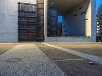 a parking lot surrounded by concrete walls and large windows with vertical lines down the middle of it