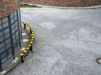 two black and yellow safety lines in front of building next to sidewalk and stairs,