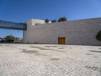 a big concrete building with an entrance and a yellow door in the center of it