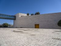 a big concrete building with an entrance and a yellow door in the center of it