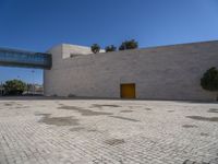 a big concrete building with an entrance and a yellow door in the center of it