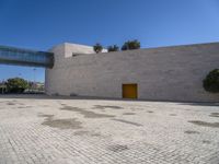 a big concrete building with an entrance and a yellow door in the center of it