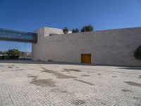 a big concrete building with an entrance and a yellow door in the center of it