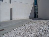 the gray concrete walls of a building have a line of steps on the left side