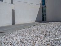 the gray concrete walls of a building have a line of steps on the left side