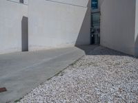 the gray concrete walls of a building have a line of steps on the left side