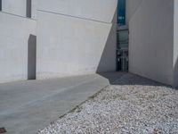 the gray concrete walls of a building have a line of steps on the left side