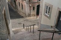 an alleyway with some cars coming up the steps and an empty street with a woman walking along