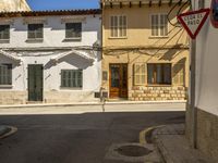 a street with no cars driving down it in europe on a sunny day with windows and door