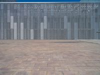 a white building with several steps and large glass panels in the facade is a mosaic that depicts a man