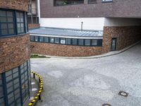 an overhead shot shows a street and building with a bus on it's side