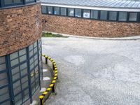 an overhead shot shows a street and building with a bus on it's side