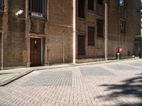 a fire hydrant sitting in the middle of an alley lined with tall brick buildings