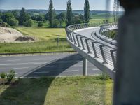 a bridge that is over some grass and some water and a highway and power lines