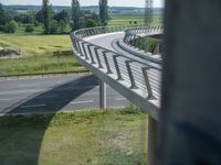 a bridge that is over some grass and some water and a highway and power lines