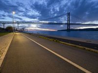 the long path leads to the large bridge, with a bright light shining from under it