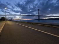 the long path leads to the large bridge, with a bright light shining from under it