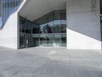 a building with glass windows that are standing near the sidewalk and a red sign that says bul