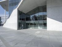 a building with glass windows that are standing near the sidewalk and a red sign that says bul