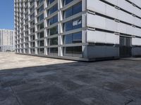 a white office building with lots of windows in the front of it and it's concrete patio