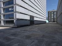 a white office building with lots of windows in the front of it and it's concrete patio