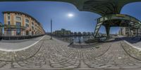 a fisheye lens of a street with some buildings and a bridge in the background