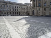 the empty sidewalk is shown in front of the building, and it seems to be lined with white stone