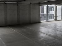 a picture of a building with an empty parking garage floor underneath and a window open