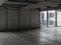 a picture of a building with an empty parking garage floor underneath and a window open