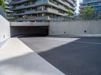 an empty parking area with a closed gated sidewalk underneath it next to some apartment complexes