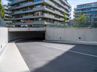 an empty parking area with a closed gated sidewalk underneath it next to some apartment complexes