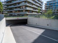 an empty parking area with a closed gated sidewalk underneath it next to some apartment complexes