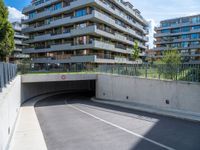 an empty parking area with a closed gated sidewalk underneath it next to some apartment complexes