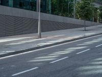 a person riding a scooter down an empty street with tall buildings on both sides